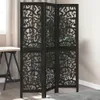 A black wooden room divider with intricate cutouts is placed in a room next to a desk and a window with curtains. Podgląd zdjęcia produktu