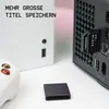 A close-up shot of an Xbox Series X console with a WD BLACK C50 expansion card inserted, and a controller and a protective cap for the expansion card on the table. Produktbild-Vorschau