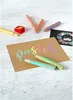 A collection of pastel-colored art supplies, including pencils and a sharpener, arranged on a light-colored surface with a piece of brown cardstock featuring the word 'Pastel' written in various pastel colors. Voir les images du produit
