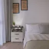 A bedroom scene with a nightstand next to a bed. Voir les images du produit
