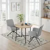A dining set with a round wooden table and two chairs in a bright, airy room with large windows. Voir les images du produit