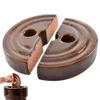Two halves of a brown ceramic sauerkraut weight are shown, with a hand placing another weight into a crock. Podgląd zdjęcia produktu