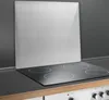 A stainless steel splashback is shown standing upright behind a black induction hob with four cooking zones. Produktbild-Vorschau