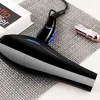 A black hairdryer is placed on a textured gray mat next to a book and a lipstick. Produktbild-Vorschau