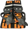 A pair of black and orange suspenders with metal clasps and leather loops. Produktbild-Vorschau