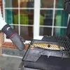 A person is grilling a fish on a barbecue grill. Produktbild-Vorschau
