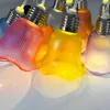 A close-up view of a string of decorative LED lights shaped like tulip bulbs in various colors. Produktbild-Vorschau