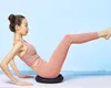 A woman is performing an exercise on a balance cushion. Voir les images du produit