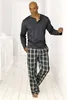 A man in pajamas stands in a hallway. Produktbild-Vorschau