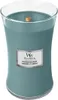 A teal colored WoodWick candle in a glass jar with a wooden wick and a silver label. Voir les images du produit