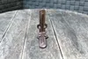 A rusted metal bracket is displayed on a wooden surface with a brick-like background. Produktbild-Vorschau