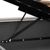 A close-up view of the mechanical support system of a bed frame, showing a gas strut and metal brackets. Produktbild-Vorschau