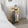 A modern bedside table next to a bed, with a phone and glasses on top.