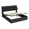 A black upholstered bed frame with the mattress support mechanism raised, revealing storage space underneath. Náhľad obrázku produktu