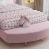 A close-up view of a pink upholstered bed frame with a matching bed bench and a unicorn pillow. Produktbild-Vorschau