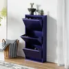 A dark blue shoe cabinet with three flip-down drawers is shown against a white wall. A wicker basket with a blanket and pillows is to the left, and a sheer white curtain is to the right.