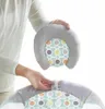A person's hands are holding a gray, U-shaped head support with a patterned insert, about to attach it to a gray bouncer seat with a similar pattern. Anteprima dell’immagine prodotto
