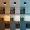 A triptych showing a black ceiling light in a kitchen setting with different lighting temperatures: warm white, neutral white, and cool blue. Podgląd zdjęcia produktu