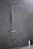 A modern shower set mounted on a gray tiled wall. Produktbild-Vorschau