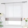 A white roman blind with a grey band at the bottom is shown hanging in front of a window. Produktbild-Vorschau