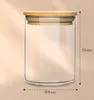 A clear glass jar with a bamboo lid, shown with dimensions indicated by dashed lines and text. Produktbild-Vorschau