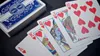 A deck of Bicycle playing cards and five cards from the deck are laid out on a dark surface. Produktbild-Vorschau