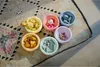 Six colorful bowls filled with various small toys and objects, arranged on a patterned rug. Anteprima dell’immagine prodotto