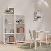 A child's room with a white bookshelf, a small table and chair, and wall art. Produktbild-Vorschau