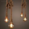 Four hanging light fixtures with Edison-style bulbs and rope cords. Produktbild-Vorschau