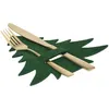 A set of gold cutlery placed on a green felt Christmas tree-shaped placemat. Produktbild-Vorschau