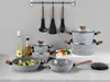 A collection of cookware and kitchen utensils displayed on a countertop against a gray wall. Náhľad obrázku produktu