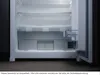 An open, empty refrigerator with shelves and drawers visible. Produktbild-Vorschau