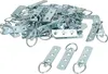 A pile of metal picture hanging D-rings and a few individual ones in the foreground, all on a white background. Podgląd zdjęcia produktu