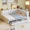A white corner daybed with storage drawers is shown in a room with decorative pictures on the wall and a floor lamp. Náhled obrázku produktu