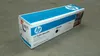 A product box for an HP toner cartridge placed on a concrete floor. Náhled obrázku produktu