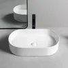 A white oval countertop sink with a black faucet in a modern bathroom setting. Náhľad obrázku produktu