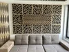 A living room with a sectional sofa in front of a decorative acoustic wall panel installation. Podgląd zdjęcia produktu