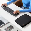 A person's hands are shown using a laptop, keyboard, and mouse on a white desk. A phone and a laptop sleeve are also visible. Produktbild-Vorschau