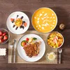 A table setting with plates of food, cutlery, and a glass of water. Náhled obrázku produktu