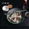 A close-up overhead shot of a salad with steak and shaved cheese, served in a bowl, with cooking utensils and ingredients like salt and peppercorns nearby. Produktbild-Vorschau