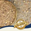 A wooden bowl filled with birdseed and scattered birdseed on a wooden surface, with a marketing badge overlay. Produktbild-Vorschau