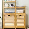 A wooden shelving unit with two laundry baskets, containing folded towels and baskets. Produktbild-Vorschau
