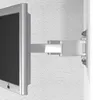 A close-up view of a TV mount attached to a wall, holding a TV. Voir les images du produit