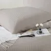A close-up view of a taupe-colored bed set with a pillow and a magazine. Podgląd zdjęcia produktu