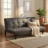 A modern living room with a grey sofa bed, throw pillows, and a blanket. Voir les images du produit