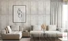 A modern living room with a sectional sofa, coffee table, and wall art. Produktbild-Vorschau
