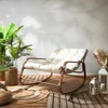 A rocking chair on a wooden deck with plants and lanterns. Voir les images du produit