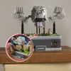 A Lego model of Geodude from Pokemon, displayed on a shelf, with a close-up inset showing a hand interacting with it. Náhľad obrázku produktu