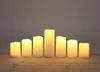 Seven LED candles of varying heights arranged in a semi-circle on a wooden surface. Produktbild-Vorschau