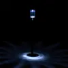 A single solar garden light illuminates the ground around it in the dark. Produktbild-Vorschau